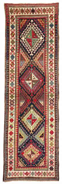 Ganja Rugs: A Gendge rug, 2nd half 19th c. Das Innenfeld zeigt einen Ausschnitt aus einem unendlichen Rapport fliesenartig gereihter, farblich konzentrisch aufgebauter Hakenrauten mit farblich diagonal viergeteilten Kernen. Der verbleibende, dunkelblaue Fond tr�gt nur wenige F�llmotive. Die Sch�nheit der Farbpalette kommt auf dem elfenbeinfarbenen Grund der Hauptbord�re sch�n zur Geltung. 345 x 103 cm