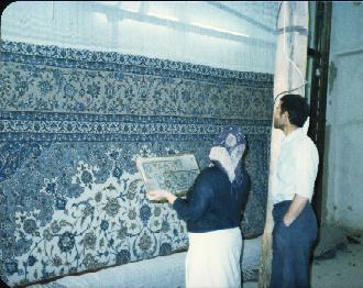 Isfahan Rugs Persian Rugs Mr. & Mrs. Malakouti inspecting one of their carpets from the back on the loom (this is an old photo, when Mr. Malakouti was young).